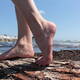 Piedi nudi sul tronco in spiaggia